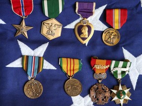 Some of the medals belonging to David Bershad are displayed on an American flag in Calgary, Alta on Saturday January 28, 2017. Bershad, who taught at the University of Calgary, was also an American war hero, who earned four purple hearts and the Legion of Merit in Vietnam serving in an elite Marine unit. Jim Wells/ Postmedia