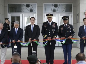 South Korean Defense Minister Song Young-moo, center left, and U.S. Gen. Vincent Brooks, center right, commander of the United Nations Command, U.S. Forces Korea and Combined Forces Command, cut tapes during an opening ceremony for the new headquarters of the U.S. Forces Korea (USFK) at Camp Humphreys in Pyeongtaek, South Korea. Friday, June 29, 2018. (AP Photo/Ahn Young-joon)