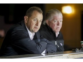 Calgary Flames general manager Brad Treliving (L) watches a Flames team practice next to Brian Burke, the Flames' president of hockey operations, at the Scotiabank Saddledome in Calgary, Alta. on Thursday, Oct. 2, 2014. The Flames would take on the Winnipeg Jets at home that night. Lyle Aspinall/Calgary Sun/QMI Agency