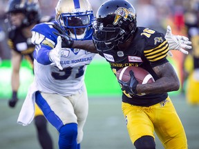Hamilton Tiger-Cats wide receiver Brandon Banks (16) tries to fend off Winnipeg Blue Bombers defensive back Maurice Leggett (31) during CFL action in Hamilton on Friday, June 29, 2018. (THE CANADIAN PRESS/Peter Power)