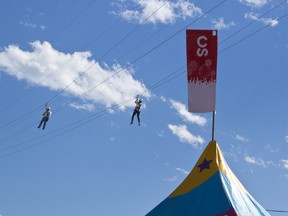 Zipliners soar through the air at the Calgary Stampede on July 13, 2018.(Zach Laing / Postmedia Network)