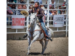 Idaho cowboy Matt Shiozawa takes a victory lap around the infield after posted a time (7.1 seconds) on Day 9 of the tie down roping event during the 2018 Calgary Stampede on Saturday, July 14, 2018. Al Charest/Postmedia