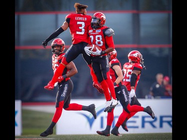 Calgary Stampeders Brandon Smith celebrates with teammate Patrick Levels after his interception against the Montreal Alouettes during CFL football in Calgary on Saturday, July 21, 2018.