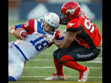 Montreal Alouettes quarterback Matthew Shiltz is sacked by Ja'Gared Davis of the Calgary Stampeders during CFL football in Calgary on Saturday, July 21, 2018.