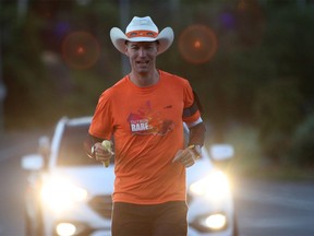 Dave Proctor is running across Canada in support of rare disease and medical study as he makes his way along Blanshard St. from Mile Zero in Victoria, B.C., on Wednesday June 27, 2018. Proctor's goal is to run 7200 kilometres in 66 days with a goal of raising 1 million dollars for research. THE CANADIAN PRESS/Chad Hipolito ORG XMIT: CAH323