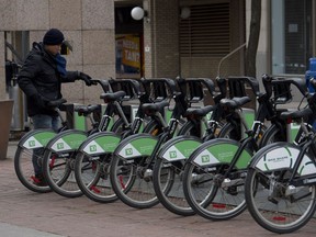 TORONTO, ON: Tuesday, December 30, 2014 - A man grabs a bike from a Bike Share Toronto station near King Street and Jarvis Street in Toronto, ON on Tuesday, December 30, 2014. (Laura Pedersen/National Post) //NATIONAL POST STAFF PHOTO