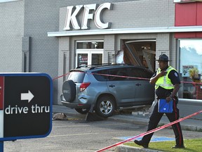 Police investigate after a vehicle crashed into the wall of a KFC in Edmonton, sending one person to hospital with a severe leg injury on July 18, 2018.