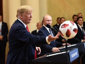 U.S. President Donald Trump, left, throws a soccer ball to his wife after receiving it by Russia's President Vladimir Putin during a joint press conference after a meeting at the Presidential Palace in Helsinki, on July 16, 2018. (BRENDAN SMIALOWSKI/AFP/Getty Images)