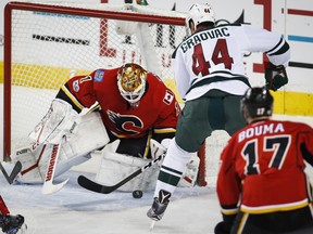 Minnesota Wild centre Tyler Graovac (44) tries to get the puck past Calgary Flames goalie Brian Elliott (1) during first period NHL hockey action in Calgary, Wednesday, Feb. 1, 2017. THE CANADIAN PRESS/Jeff McIntosh ORG XMIT: JMC105