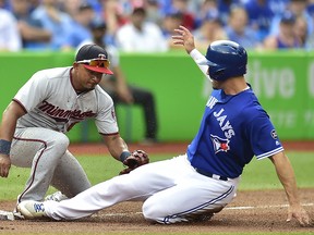 Minnesota Twins third baseman Eduardo Escobar (5) applies the tag as Toronto Blue Jays left fielder Randal Grichuk (15) slides into third Wednesday, July 25, 2018 in Toronto. (THE CANADIAN PRESS/Frank Gunn)