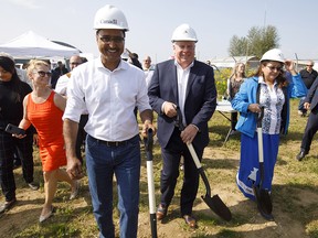 Minister of Infrastructure and Communities Amarjeet Sohi, left, and Kinder Morgan Canada president Ian Anderson make their way to a ground-breaking ceremony at the Trans Mountain stockpile site in Edmonton on Friday July 27, 2018.