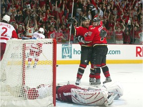 Curtis Joseph #31 of the Detroit Red Wings lays dejected in his crease as Martin Gelinas #23 of the Calgary Flames celebrates his overtime game-winning goal with teammate Jarome Iginla #12 during the first overtime period of Game six of the Western Conference Semifinals during the 2004 NHL Stanley Cup Playoffs May 3, 2004 at the Pengrowth Saddledome in Calgary, Alberta, Canada.
