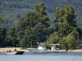 Emergency workers patrol an area Friday, July 20, 2018, near where a duck boat capsized the night before resulting in at least 13 deaths on Table Rock Lake in Branson, Mo. Workers were still searching for four people on the boat that were unaccounted for. (AP Photo/Charlie Riedel) ORG XMIT: MOCR101