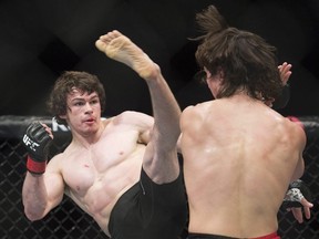 Olivier Aubin-Mercier, from Canada, left, attempts a kick to the head of David Michaud, from the United States, during their UFC 186 lightweight fight in Montreal, Saturday, April 25, 2015.