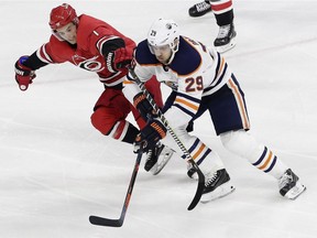 Carolina Hurricanes' Derek Ryan (7) and Edmonton Oilers' Leon Draisaitl (29), of Germany, chase the puck during the third period of an NHL hockey game in Raleigh, N.C., Tuesday, March 20, 2018. Edmonton won 7-3.