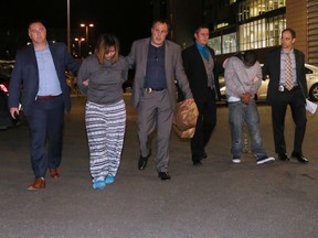 Yu Chieh Liao, left, and Tewodros Mutugeta Kebede are taken into custody in Calgary on Oct. 10, 2017.