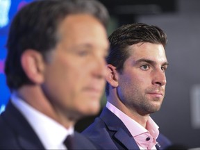 Maple Leafs president Brendan Shanahan (left) sits at the podium with free agent signing John Tavares in Toronto on Sunday, July 1, 2018.