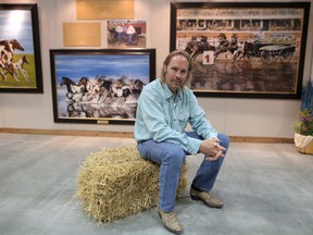 Paul Van Ginkel poses with some of his paintings in the Western Showcase at the Calgary Stampede on Thursday July 5, 2018. Leah Hennel/Postmedia