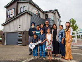 Karanbir Sidhu, centre, from Calgary stands with family in front of the 2018 Rotary Dream Home he won in the 2018 Calgary Stampede lotteries. Prize winners were presented with their prizes on Tuesday July 24, 2018. New this year Sidhu also won a cheque for $100,000. The dream home will soon be moved to the community of Walden. Gavin Young/Postmedia