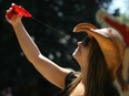 Calgary's Jill Kowalchuk used a squirt gun as she tried to beat the heat at the Calgary Stampede grounds on Saturday as temperatures soared into the 30's. Credit: Colleen De Neve / Calgary Herald