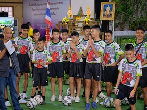 Twelve boys and their coach, Ekkapol Chantawong (Right), from the "Wild Boars" soccer team arrive for a press conference for the first time since they were rescued from a cave in northern Thailand last week, on July 18, 2018 in Chiang Rai, Thailand.