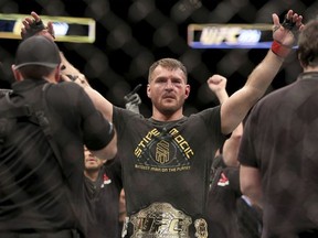 In this Jan. 21, 2018, file photo, Stipe Miocic gestures after a win over Francis Ngannou during a heavyweight championship mixed martial arts bout at UFC 220, in Boston. Miocic will get the biggest paycheck of his career at UFC 226 for the biggest test of his fighting life against light heavyweight champ Daniel Cormier.