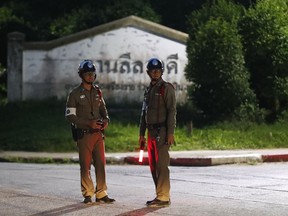 Police man guard a junction for an ambulance believed to be carrying one of the rescued boys from the flooded cave, in the Mae Sai district of Chiang Rai province, northern Thailand, Monday, July 9, 2018.