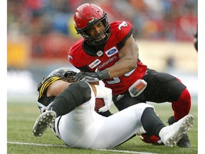 Calgary Stampeders lineback Jameer Thurman, right, tackles Nikita Whitlock during their game at McMahon Stadium in Calgary, on Saturday June 16, 2018. Leah Hennel/Postmedia