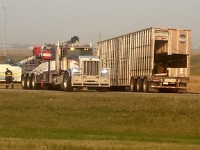 A cattle truck is placed back on its wheels after flipping over on Stoney Trail N.E. on Friday, Aug. 10, 2018.