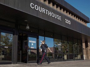 A judge has given a woman who was charged after two young children were found in a freezing car late at night in southern Alberta a conditional discharge. A police officer arrives at the provincial court building in Lethbridge, Alta., Wednesday, Sept. 23, 2015.