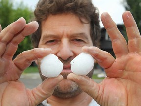 Kemal Ciftci, who was working on a house on Canterbury Place SW, holds up hailstones in the Canyon Meadows neighborhood in Calgary on Thursday, August 2, 2018. Yet another violent storm rolled through the city, pelting neighborhoods with heavy rain and hail. Jim Wells/Postmedia