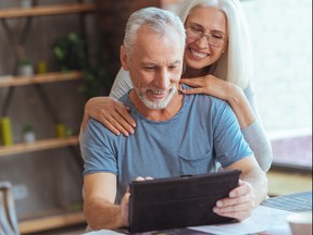 Retired positive man using tablet with his wife