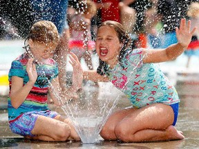 Sienna Henderson (left), 8, and Taylor Olesko, 9, cool down at the Bowness Park wading pool as the heat wave continues in Calgary.