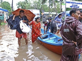 Flood victims are evacuated to safer areas in Kozhikode, in the southern Indian state of Kerala, Thursday, Aug. 16, 2018.