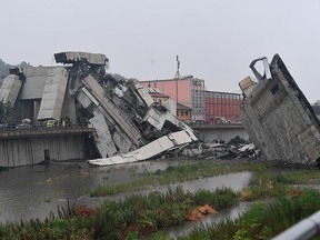 Rescuers work among the rubble of the collapsed Morandi highway bridge in Genoa, northern Italy, Tuesday, Aug. 14, 2018.