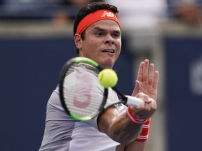 Milos Raonic returns a shot to American Frances Tiafoe at the Rogers Cup in Toronto. THE CANADIAN PRESS