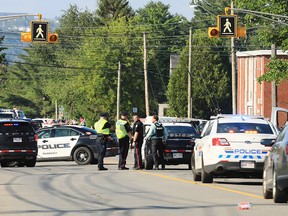 Police officers survey the area of a shooting in Fredericton, N.B. on Friday, Aug. 10, 2018.