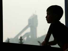 Andres Cortes looks out the window from soccer camp as kids from Sport and Adventure Camps at Winsport are stuck with indoor activities as thick smoke has invaded the city of Calgary on Thursday August 16, 2018. Darren Makowichuk/Postmedia