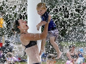 Mom, Carolyn Carey cools down with her son, Spencer, 2, at the Bowview Outdoor Pool as temperatures soared in Calgary on Monday July 30, 2018.