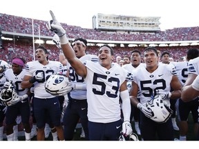 Isaiah Kaufusi (#53), of the BYU Cougars, celebrates with teammates after the game against the Wisconsin Badgers at Camp Randall Stadium on Saturday in Madison, Wisc. BYU won 24-21.
