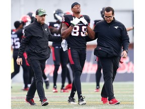 Calgary Stampeders receiver Kamar Jorden is helped off the field after suffering leg injury against the Edmonton Eskimos during the Labour Day Classic in Calgary on Monday. Photo by Al Charest/Postmedia.