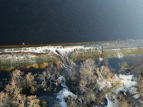 In this photo released Friday, Sept. 21, 2018, by Duke Energy, grey material that Duke Energy characterized as lightweight coal combustion byproducts could be seen Friday floating on the top of the lake, near Wilmington, N.C.