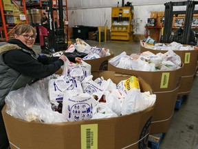 Jen Little with the Calgary Food Bank helps with the organization of some of the thousands of pounds of food donated during a city-wide food drive. Bins of donated food began arriving at the food bank on Saturday September 15, 2018. Gavin Young/Postmedia