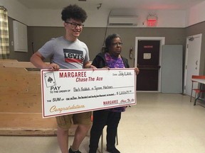 Tyrone MacInnis, left, and Barb Reddick, right, accept their Chase the Ace lottery prize in this undated handout photo. An agreement has been reached between a Nova Scotia woman and her nephew in a dispute over a million-dollar Chase the Ace jackpot that made headlines across Canada. Barbara Reddick sued her nephew Tyrone MacInnis after the grand prize of a charity fundraiser in rural Cape Breton was divided between the two, leaving them each with $611,319.50.THE CANADIAN PRESS/HO, Bernice Curley, Chase The Ace Margaree *MANDATORY CREDIT*