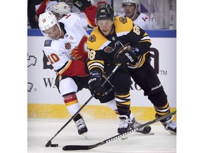 Derek Ryan (10) of the Calgary Flames and David Pastrnak (88) of the Boston Bruins battle for control of the puck during the third period of their 2018 NHL China Games hockey game in Beijing, China, Wednesday, Sept. 19, 2018. Boston beat Calgary, 3-1.