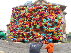 Heather Brook joins her son Jake England, 23 months old, as they check out a Beakerhead installation called Dreams Never Die on 11 Ave SE in Calgary on  Wednesday, September 19, 2018. The installation, which is part of the Beakerhead exhibition, is designed by artist Maria Galura and was inspired by the movie Up, contains hundreds of weather resisent and bio-degradable balloons which wraps part of the house in Victoria park. Jim Wells/Postmedia