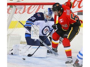 Winnipeg Jets Laurent Brossoit makes a save on a shot by Dillon Dube of the Calgary Flames during NHL pre-season hockey at the Scotiabank Saddledome in Calgary on Monday, September 24, 2018. Al Charest/Postmedia