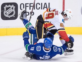 Calgary Flames forward Dillon Dube flattens the Vancouver Canucks' Kole Lind during the second period of a pre-season NHL hockey game in Vancouver, B.C., on Wednesday September 19, 2018.