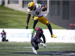 Edmonton Eskimos' C.J. Gable, top, leaps over a tackle from Calgary Stampeders' Ciante Evans during first half CFL football action in Calgary, Monday. CP file.