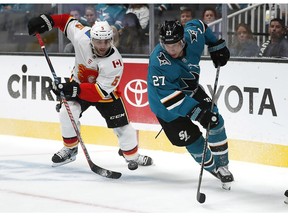 Calgary Flames defenceman Mark Giordano (5) and San Jose Sharks right winger Joonas Donskoi (27) compete for the puck during the first period of a preseason NHL hockey game in San Jose, Calif., Thursday, Sept. 27, 2018.